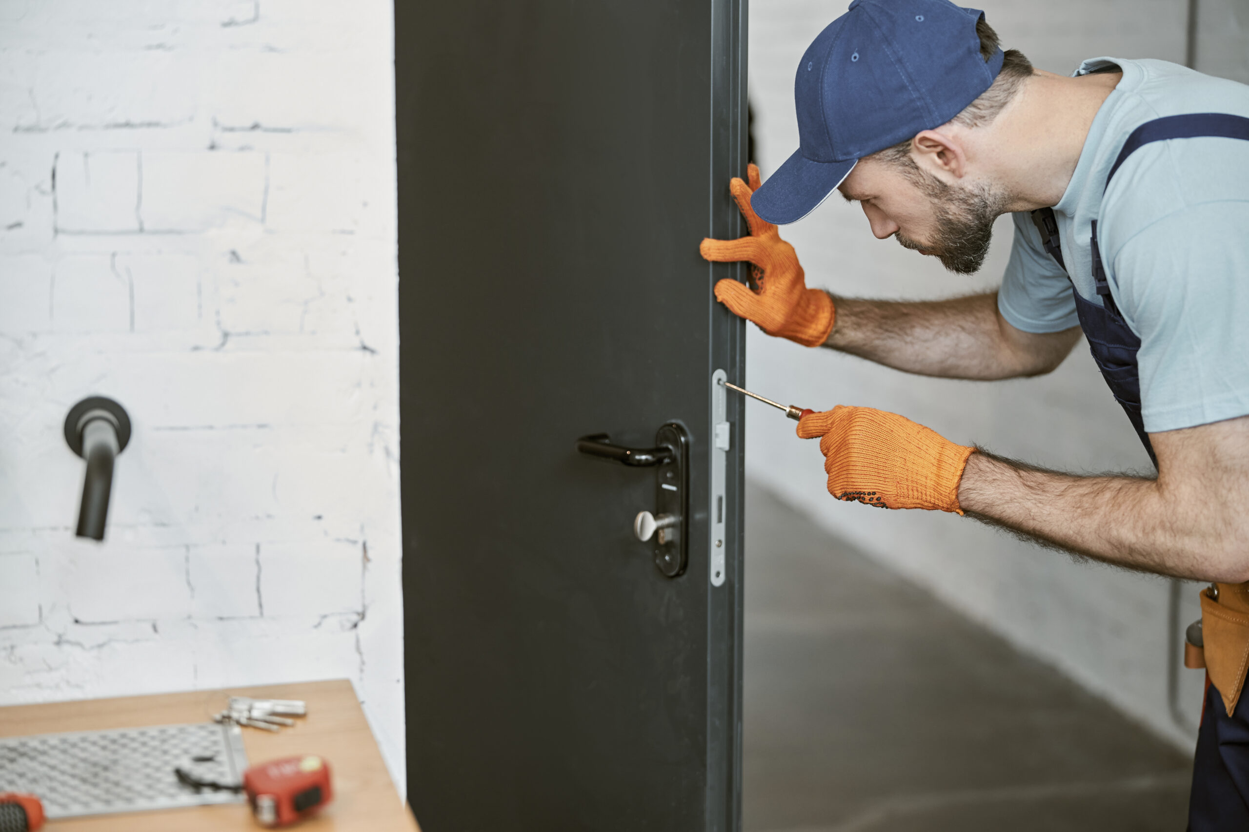 Technician adjusting door hardware with a screwdriver